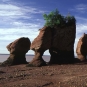 Photographie couleur de hautes formations rocheuses sur une plage