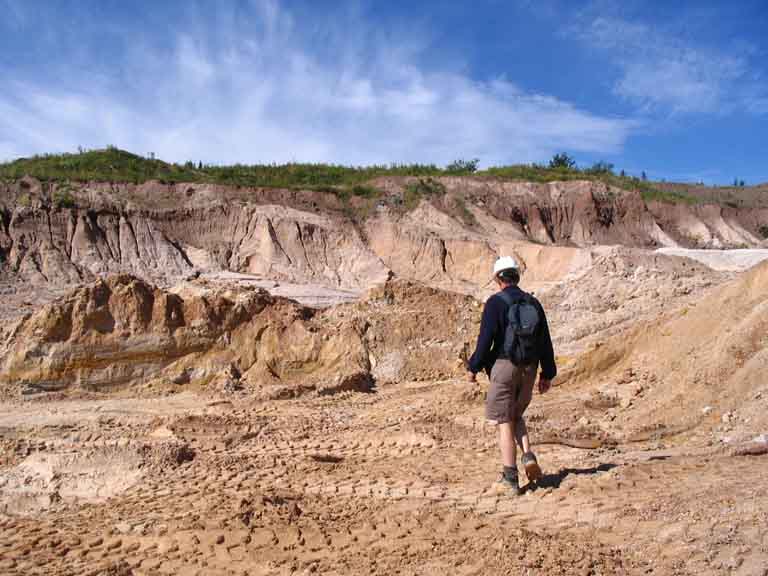 Colour photograph of a man walking across white rocks in the quarry