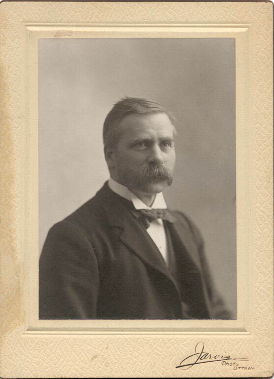 Black and white photograph of man in a suit with a mustache