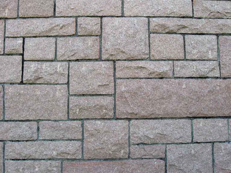 Photographie couleur d’un mur de pierres carrées et rectangulaires