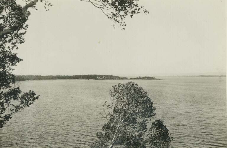 Black and white photograph of bay and island in distance