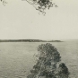 Black and white photograph of bay and island in distance