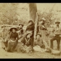 Black and white photograph of five women and three men in front of a tree