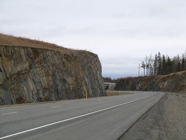 Colour photograph of rocky outcrop and highway